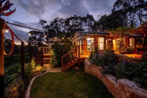 a small house with a fence and a yard at Delphi, Adelaide Hills Garden BnB in Mylor