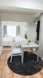 a room with a white table and a bed and a desk at Sun Park Heights in Kobe