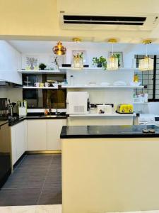 a kitchen with white cabinets and a black counter top at Cosy City Centre Living at WTC in Kuala Lumpur