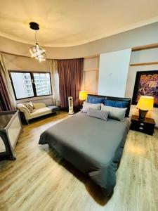 a bedroom with a large bed and a living room at Cosy City Centre Living at WTC in Kuala Lumpur