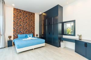 a bedroom with a blue bed and a wall at Dara pool villa in Ban Bang Liang