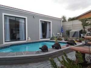 Cape Town的住宿－Mi Amor self catering apartment，游泳池周围坐着3个嬉皮士