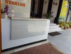 un mostrador blanco en un edificio con macetas en A & A Residence Syariah en Sukarami