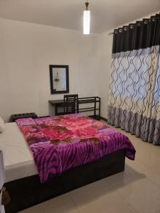 um quarto com uma cama com um cobertor roxo em White City Villa em Nuwara Eliya