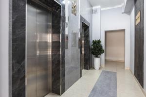 a hallway with a metal elevator in a building at Апартаменты Comfort Life 91 in Almaty