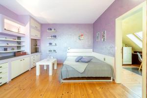 um quarto com paredes roxas, uma cama e uma mesa em Zen Home pLOVEdiv em Plovdiv