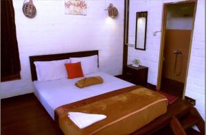 a bedroom with a large bed with white sheets and red pillows at Bantal Guling Villa in Lembang