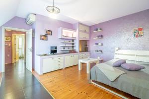 Cet appartement comprend une chambre avec des murs violets, un lit et une cuisine. dans l'établissement Zen Home pLOVEdiv, à Plovdiv