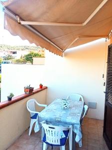 een tafel en stoelen op het balkon van een huis bij Casa freogan in Castelsardo