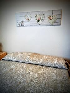 een slaapkamer met een bed met harten aan de muur bij Casa freogan in Castelsardo