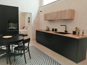 a kitchen with black cabinets and a table with chairs at Casa Lorenzo in Avola