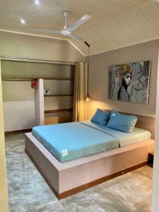 a bedroom with a bed with a ceiling fan at very nice new apartment 80 meters from the sea in Ambondrona