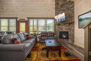 a living room with a couch and a fireplace at Creekside Splendor cabin in Sevierville