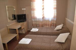 a room with two beds and a desk and a mirror at B&B Bed& Fly - Mamma Mia in Azzano San Paolo