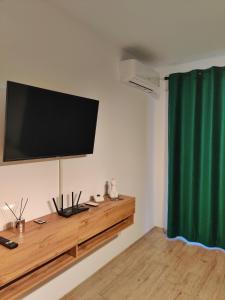 a flat screen tv on the wall of a room at Rosco Apartment Transalpina in Alba Iulia