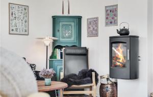 uma sala de estar com lareira e uma cadeira em Beautiful Home In Pandrup With Wifi em Pandrup