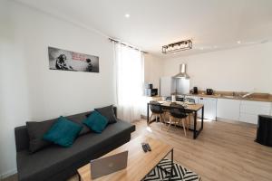 a living room with a couch and a table at KASA INDUS - Climatisation - Cosy et équipé in Saint-Chamond