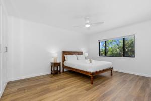 um quarto branco com uma cama e uma janela em Villa Marina by the Sea - Pet Friendly em Kingscliff