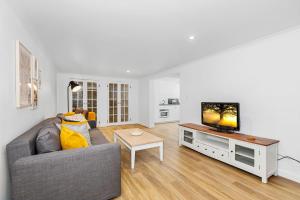 uma sala de estar com um sofá e uma televisão em Villa Marina by the Sea - Pet Friendly em Kingscliff
