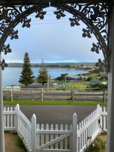 an archway with a white fence and a view of a lake at Harbour Master's Cottage in Stanley