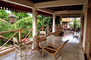a porch with chairs and a table on a patio at Villa Varuna in Legian