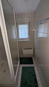 an empty bathroom with a shower and a window at Familie Drescher in Radensdorf