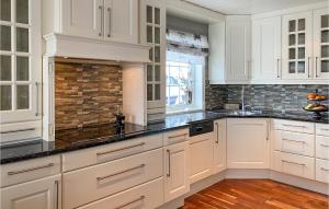 a kitchen with white cabinets and black counter tops at Beautiful Home In Stryn With Kitchen in Stryn