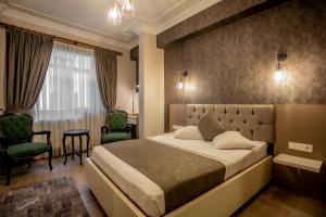 伊斯坦堡的住宿－佩拉國會大廈酒店，一间卧室配有一张床、两把椅子和一个窗户