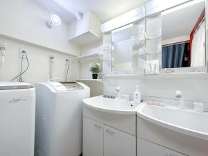 a white bathroom with a washing machine and a sink at nestay suite tokyo tabata 03 in Tokyo +72 photos