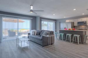 a living room with a couch and a kitchen at Sea La Vie Beach Oceanfront Patio Pet Friendly in Jacksonville Beach