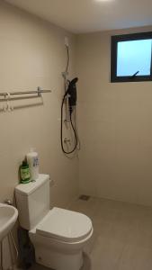een badkamer met een toilet en een telefoon aan de muur bij Cozy Southville Bangi Free parking Wifi Netflix in Bangi