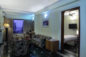 Habitación con dormitorio con cama y espejo. en Hiltop Hotel en Bombay