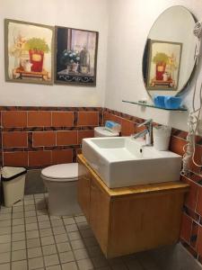 La salle de bains est pourvue d'un lavabo, de toilettes et d'un miroir. dans l'établissement Shenten Homestay, à Jincheng