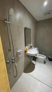 a bathroom with a shower and a sink and a toilet at Alexa Meisterstadt pollux habibie in Batam Center