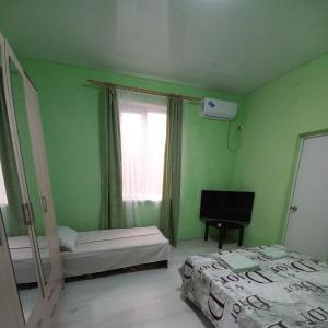 Habitación verde con 2 camas y ventana en Guest house na Myasnikova Diamond en Novy Afon