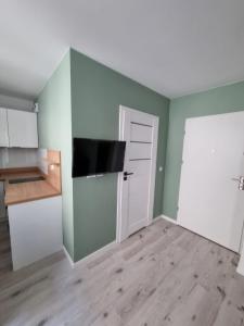 an empty room with a kitchen and a door at Apartamenty Katowice Chopina 16 in Katowice