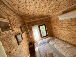 Habitación pequeña con cama y ventana en La Padurea Mica en Cărbunari