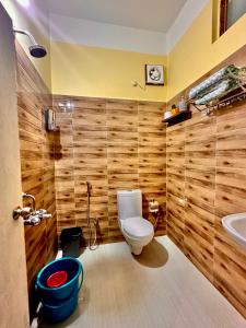 a bathroom with a toilet and a sink at Three Little Birds Homestay in Guwahati