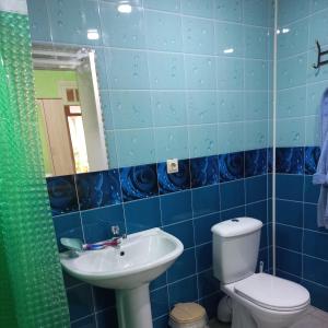 a blue tiled bathroom with a toilet and a sink at Guest house na Myasnikova Diamond in Novy Afon