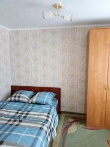 1 dormitorio con 1 cama y armario de madera en 3-х комнатная квартира район ЖД вокзала, en Kostanái