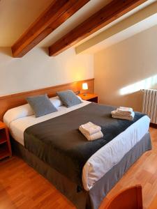 1 dormitorio con 1 cama grande y 2 toallas. en Hotel Estel, en Berga