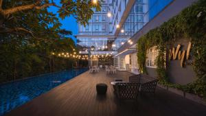 um edifício com piscina, mesas e cadeiras em Veranda Hotel Pakubuwono em Jakarta