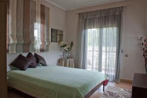 a bedroom with a green bed and a window at Villa Maltina in Kassandrinón