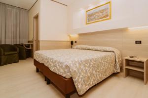 a hotel room with a bed and a chair at Hotel Valentino Centro Storico in Orvieto
