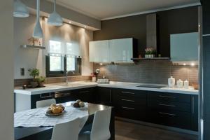 a kitchen with a table with a bowl of fruit on it at Villa Maltina in Kassandrinón +46 photos
