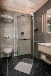 Un baño con ducha, inodoro y lavabo. en Hotel Pera Capitol, en Estambul