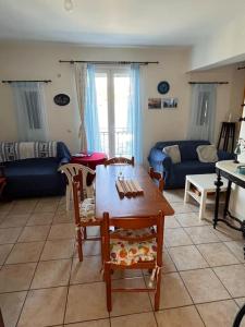 ein Wohnzimmer mit einem Tisch, Stühlen und einem Sofa in der Unterkunft Καλοκαιρινό σπίτι δίπλα στη θάλασσα in Gialiskari