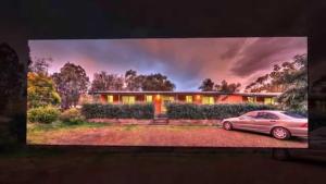 a tv screen with a car parked in front of a house at Sandy Hollow Tourist Retreat in Sandy Hollow
