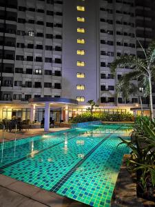 a swimming pool at night in front of a building at Condominium at Spring Residences near Airport in Manila