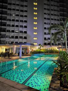 una piscina di notte di fronte a un edificio di Condominium at Spring Residences near Airport a Manila